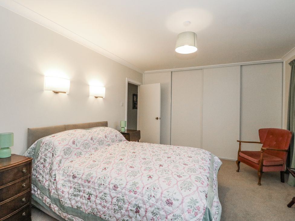 A bedroom with a bed and a chair at Carnmhor in Aberdeen