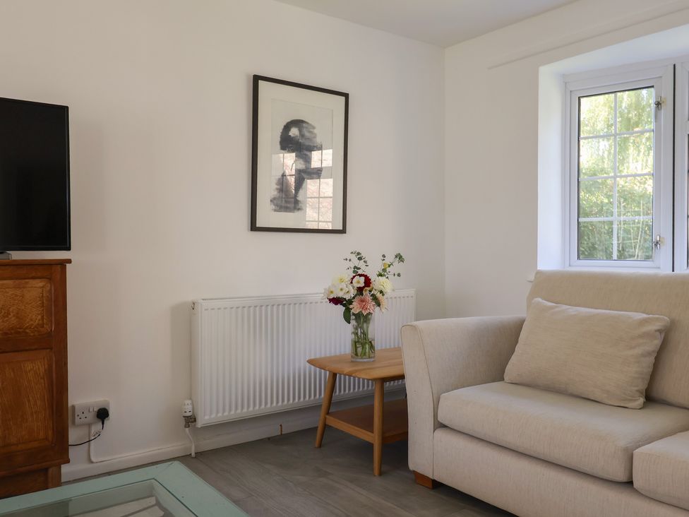 A living room with a television and sofa at Oakwood in Chideock