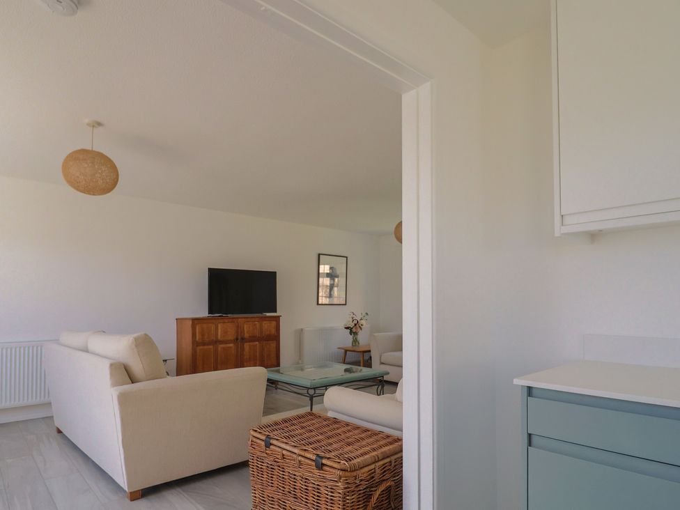 A living room with a television and seating area at Oakwood in Chideock