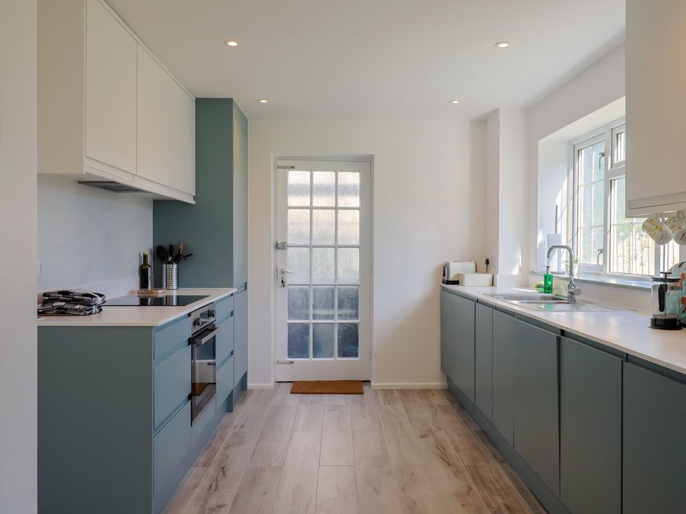 A kitchen featuring a sink, cooker, and door at Oakwood in Chideock