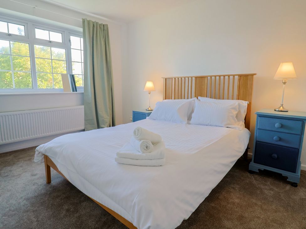 A bedroom with a bed and bedside tables at Oakwood in Chideock