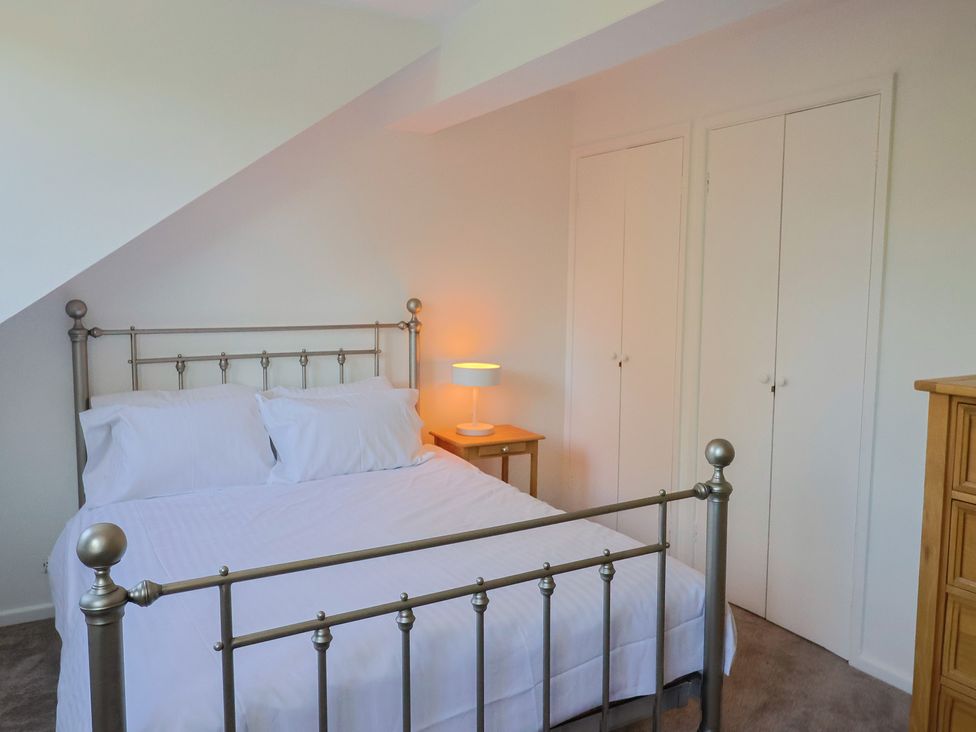 A bedroom featuring a bed and lamps at Oakwood in Chideock