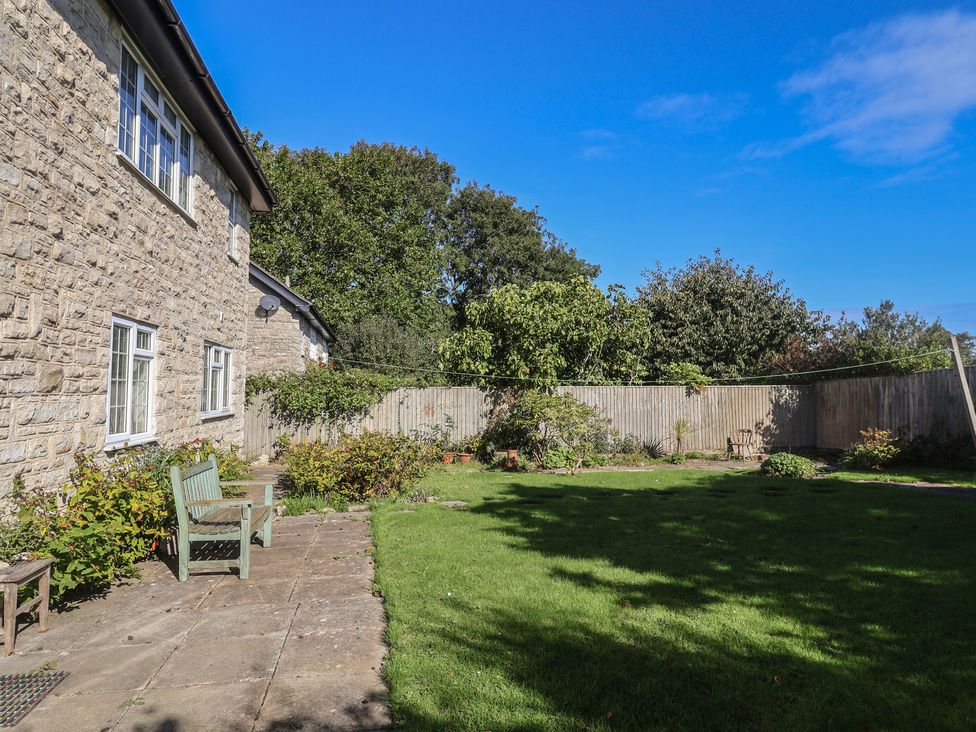 A garden with a bench and grass at Oakwood in Chideock
