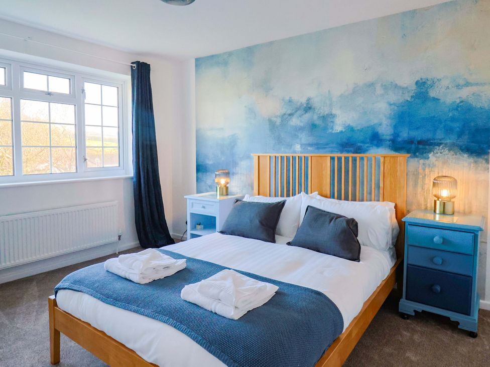 A bedroom with a bed and bedside tables at Oakwood in Chideock