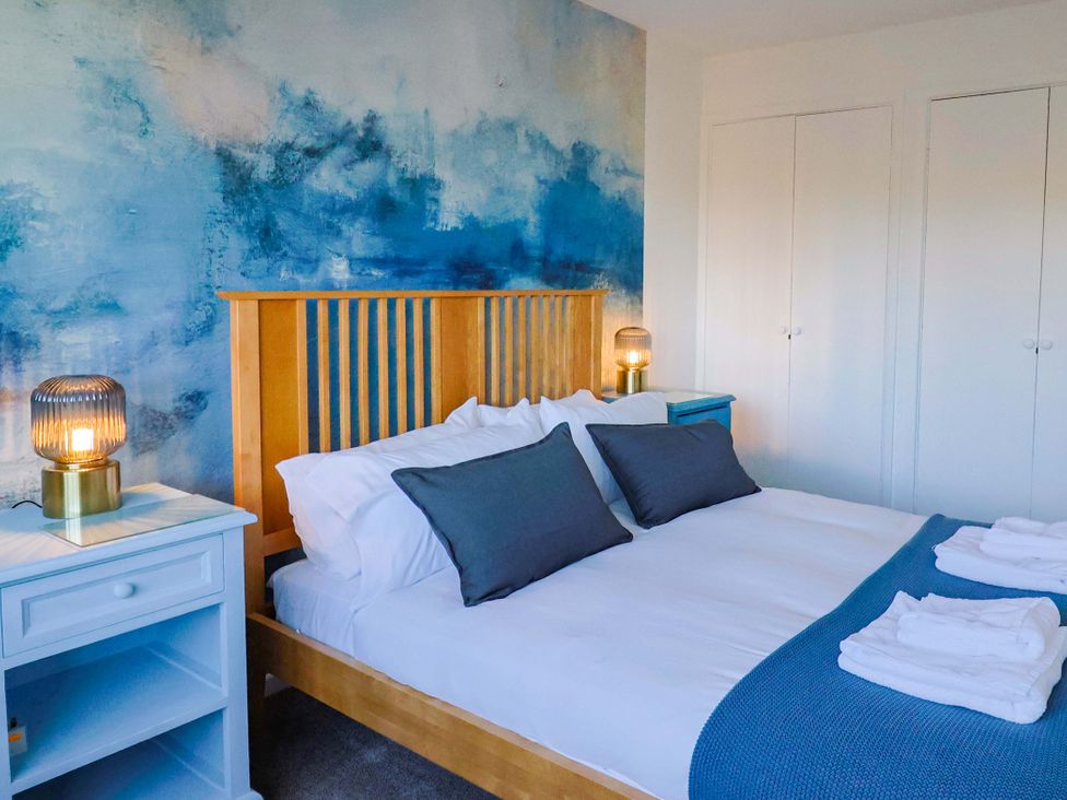 A bedroom with a bed and bedside tables at Oakwood in Chideock