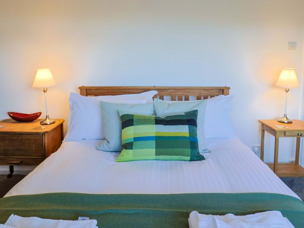 A bedroom with a bed and side tables at Oakwood in Chideock