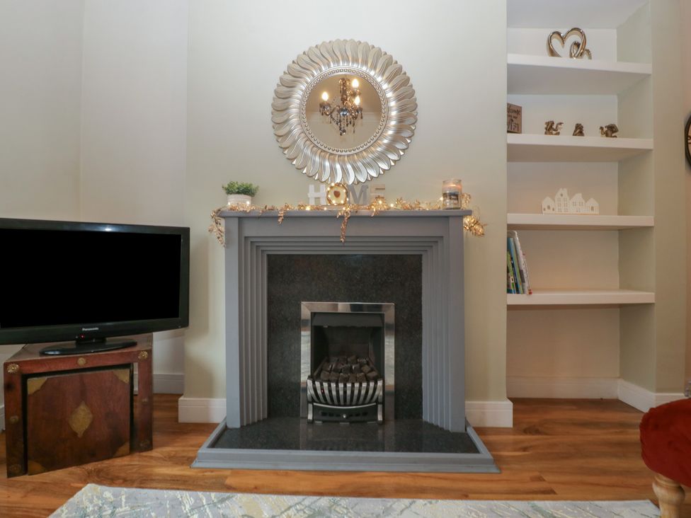A living room with a fireplace and television at Gavin and Stacey House in Barry