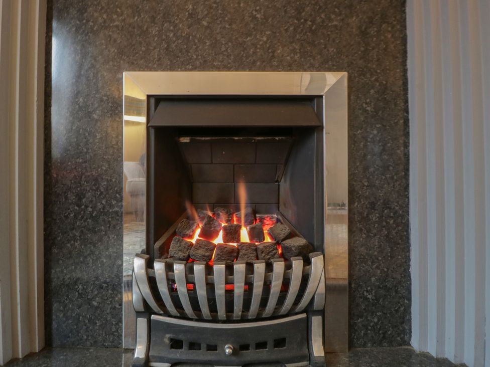 A fireplace with glowing coals at Gavin and Stacey House in Barry