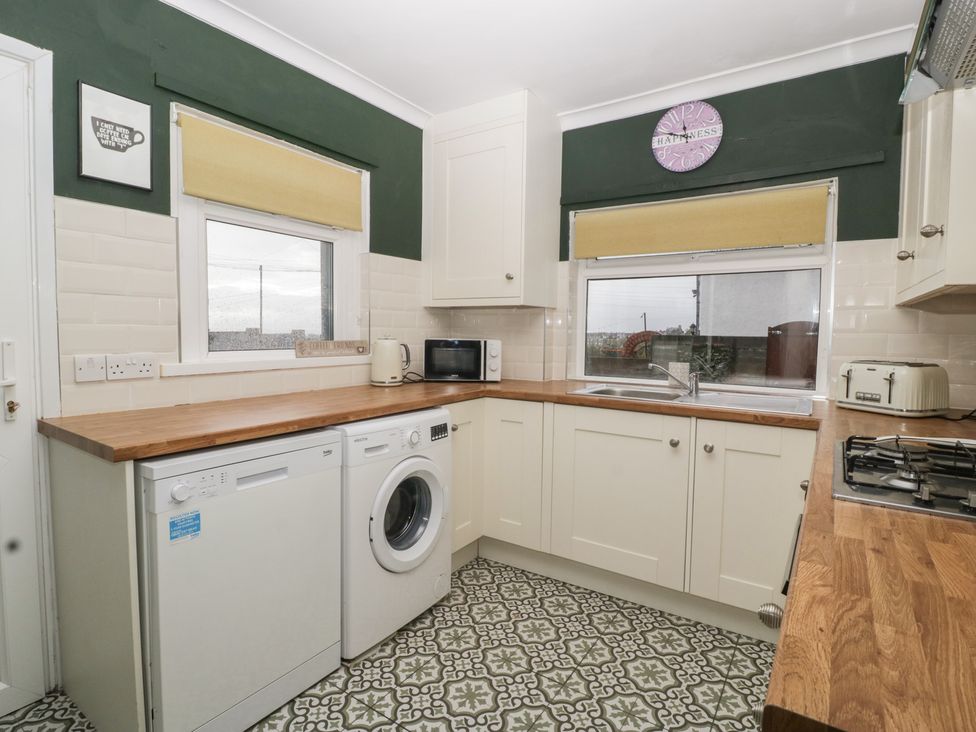 A kitchen with washing machine and microwave at Gavin and Stacey House in Barry