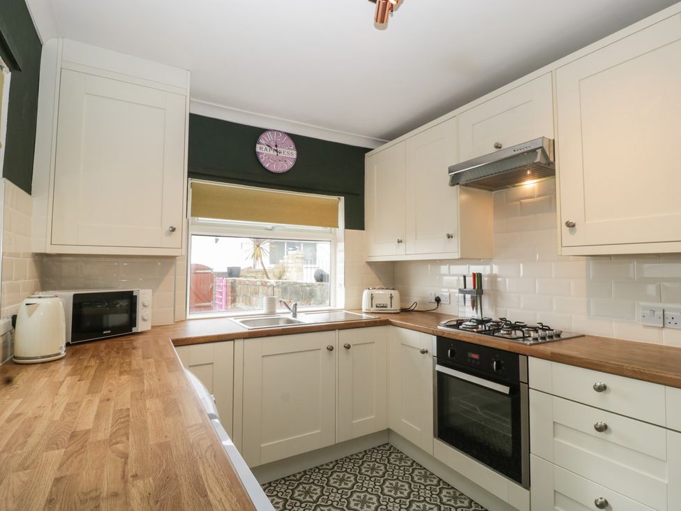 A kitchen with kitchen appliances and cabinets at Gavin and Stacey House in Barry