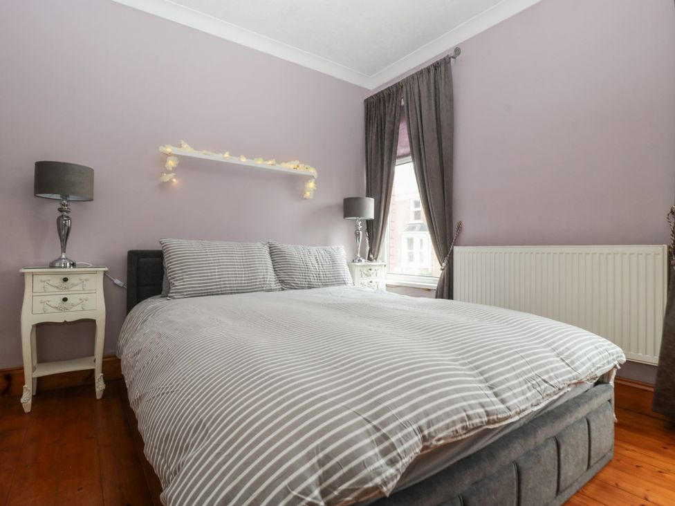 A bedroom with a bed and nightstands at Gavin and Stacey House in Barry