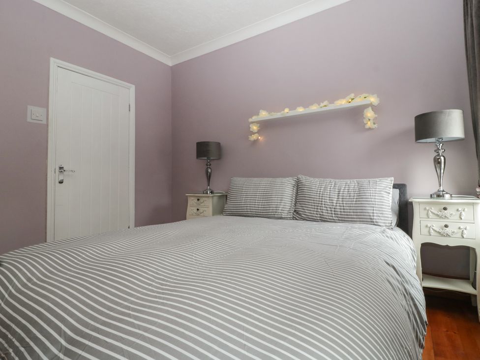 A bedroom with a bed and bedside tables at Gavin and Stacey House in Barry