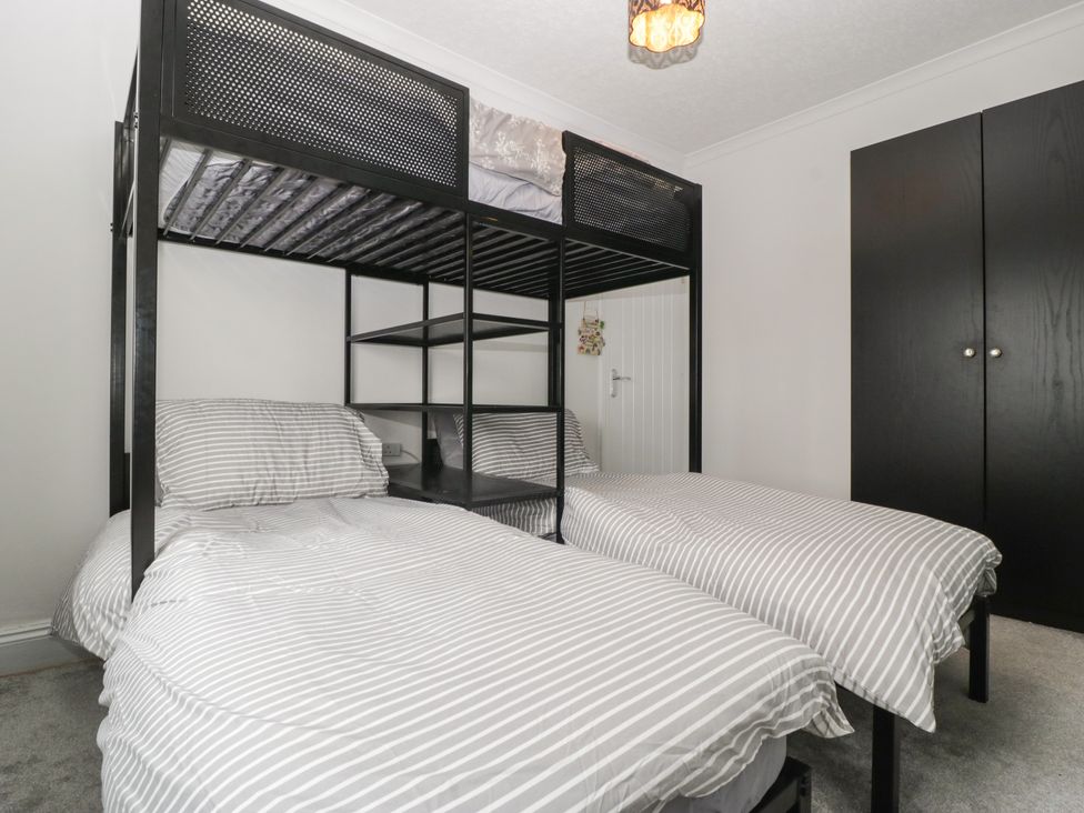 A bedroom with a bunk bed and a wardrobe at Gavin and Stacey House in Barry