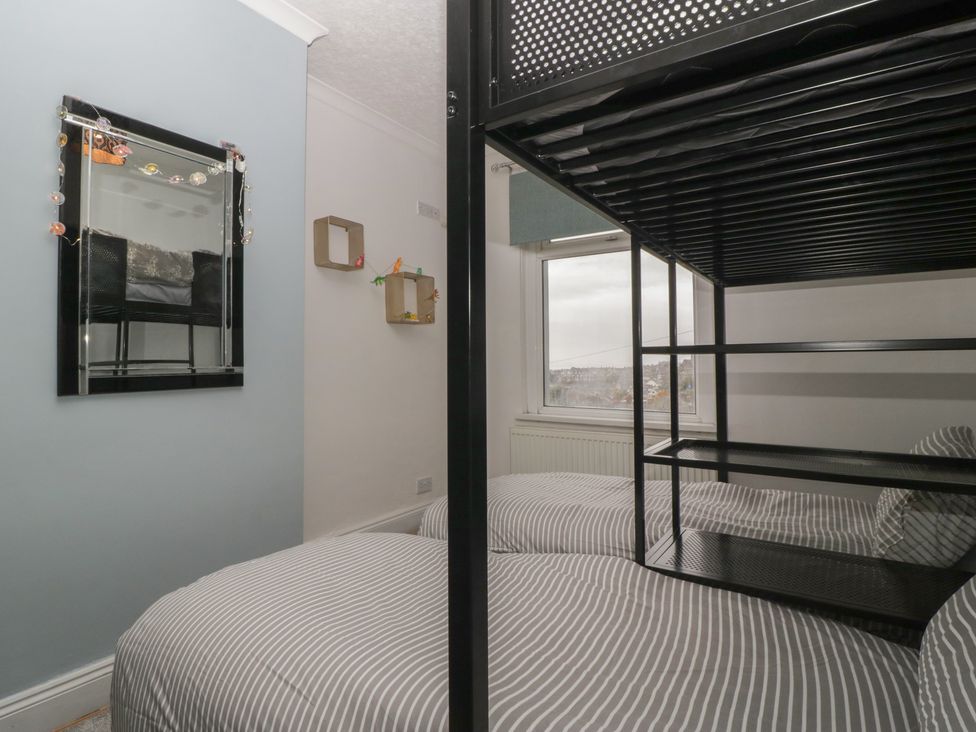 A bedroom with a bunk bed and a mirror at Gavin and Stacey House in Barry