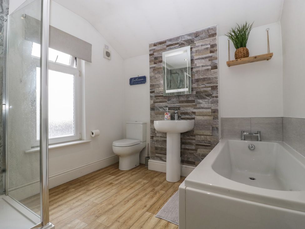 A bathroom with a sink, toilet, shower, and bathtub at Gavin and Stacey House in Barry