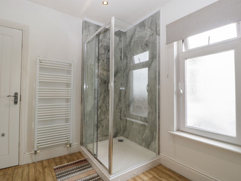 A bathroom with a shower and radiator at Gavin and Stacey House in Barry