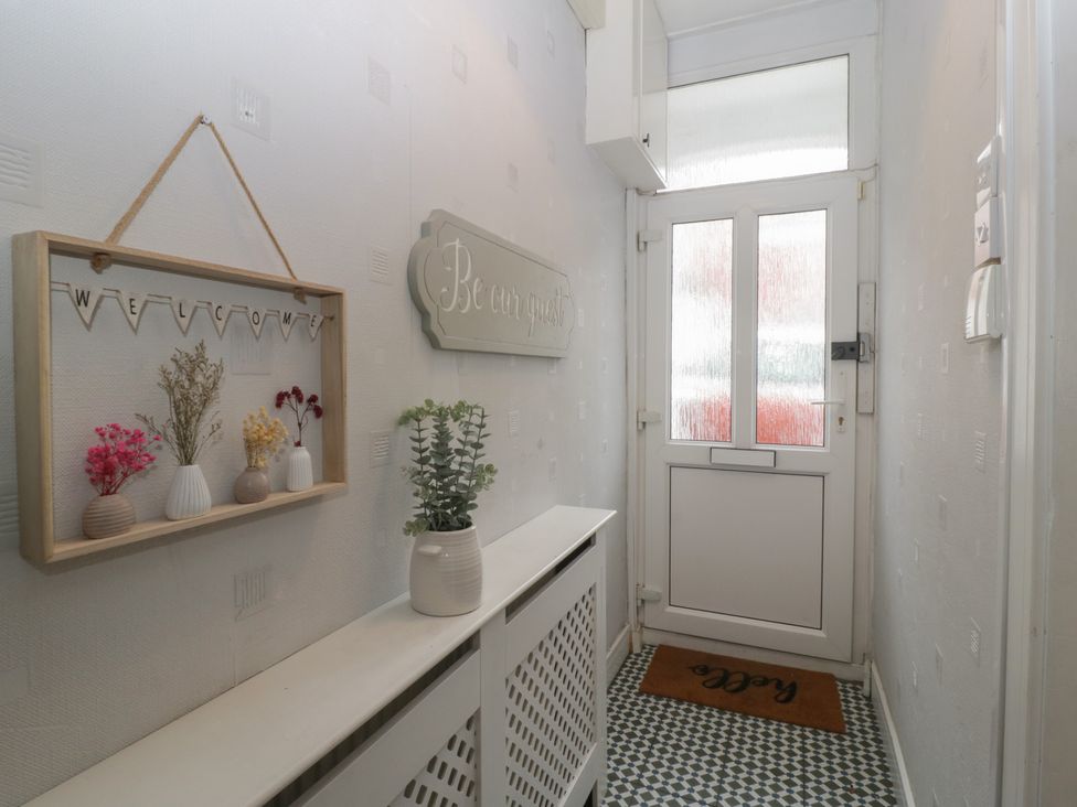 A hallway with a welcome sign and vases at Gavin and Stacey House in Barry