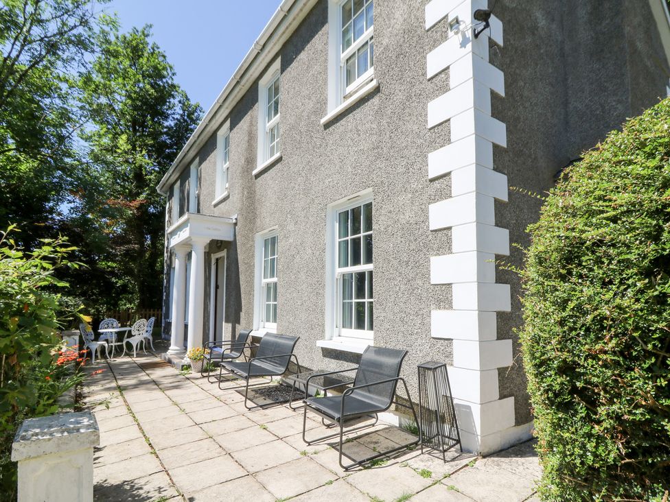 A house exterior with seating area and table at Ty Caredig in Swansea