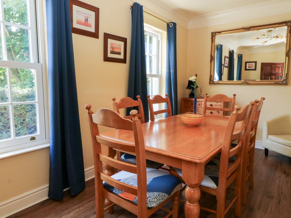 A dining room with a wooden table and chairs at Ty Caredig Swansea