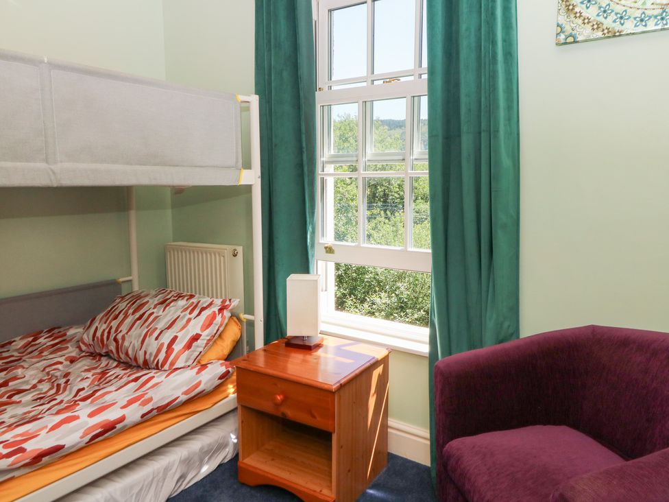 A bedroom with a bunk bed and a bedside table at Ty Caredig Swansea