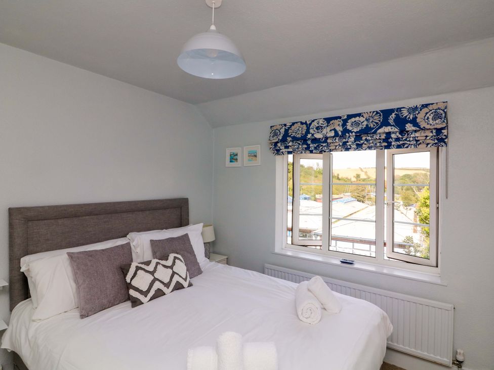 A bedroom with a bed and window at Rockside in Salcombe
