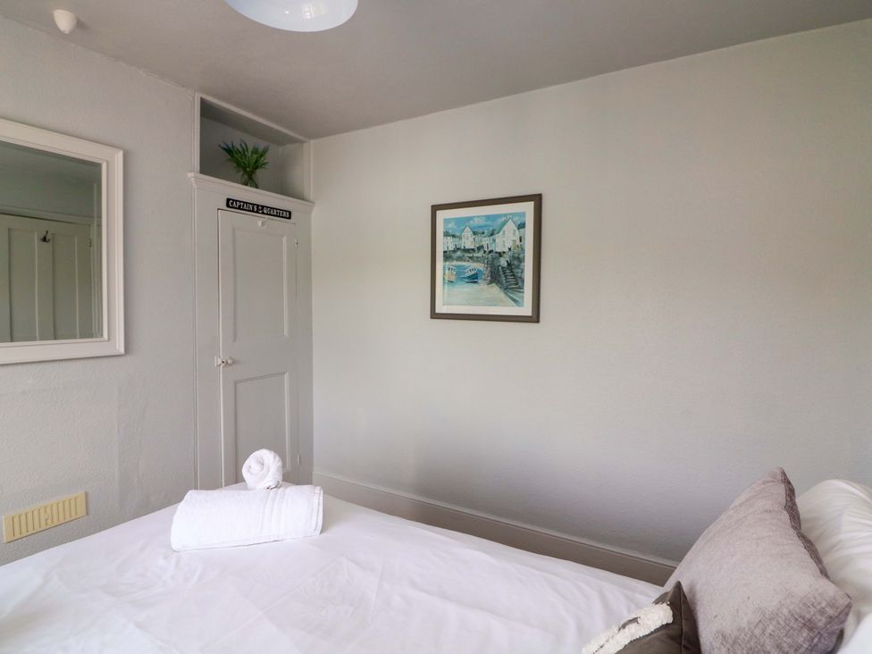 A bedroom with a bed and artwork on the wall at Rockside in Salcombe