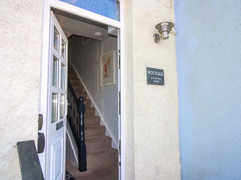 An entryway with a staircase and front door at Rockside in Salcombe