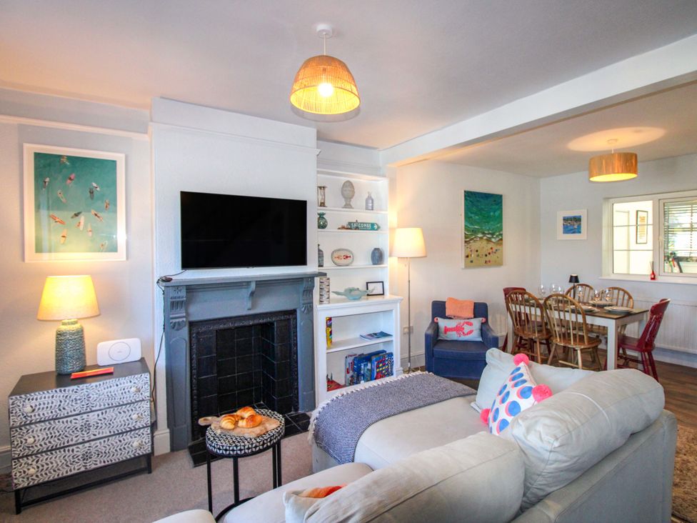 A living room with a television and sofa at Rockside in Salcombe