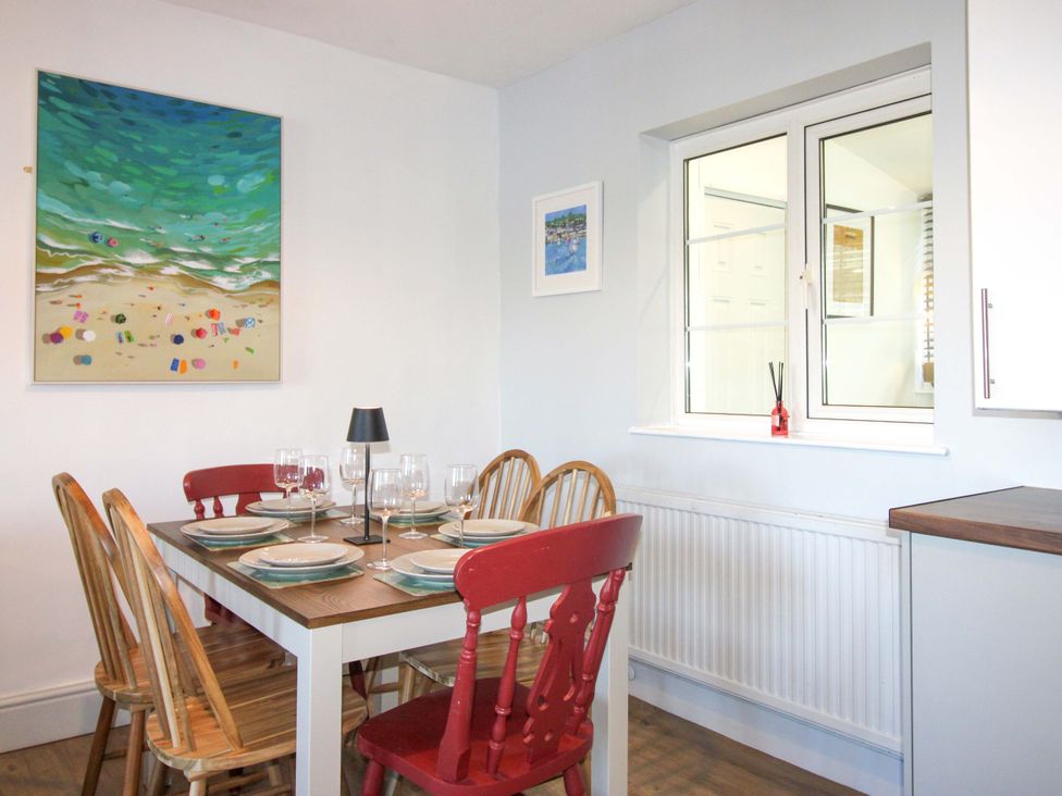 A dining room with a table and chairs at Rockside in Salcombe