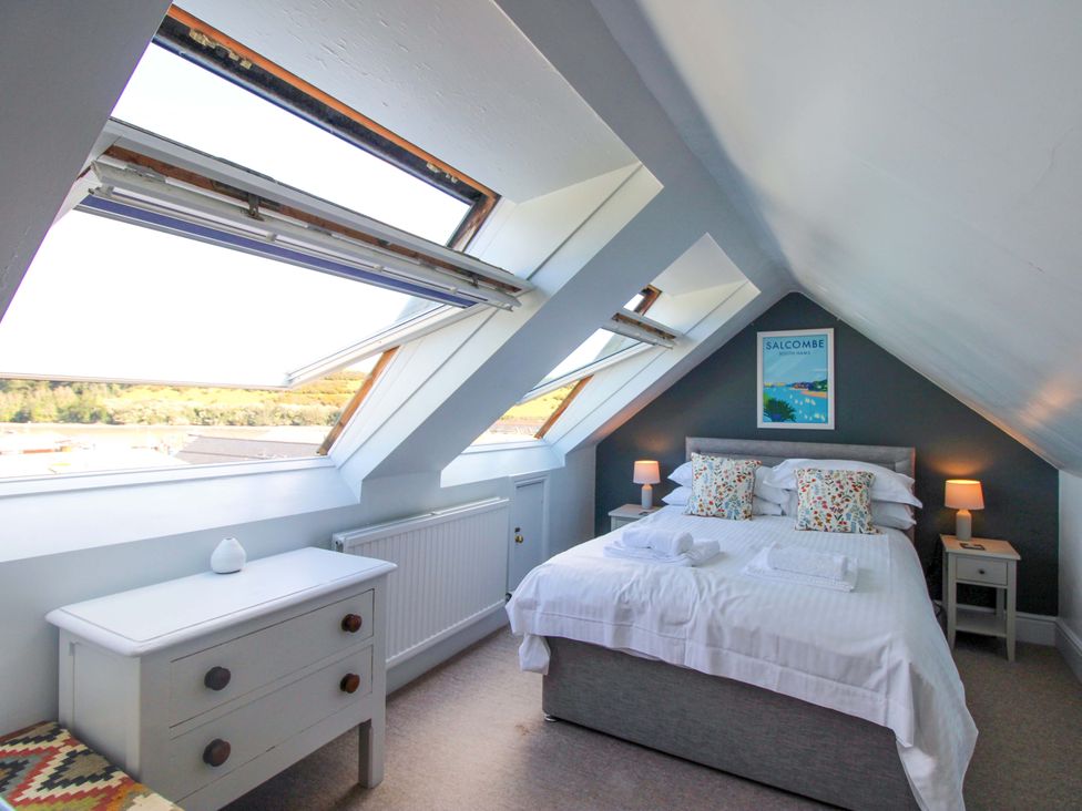 A bedroom with a bed and nightstands at Rockside in Salcombe
