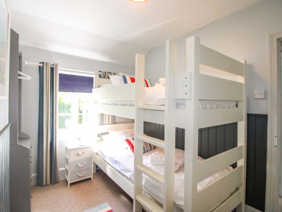 A bedroom with bunk beds and a nightstand at Rockside in Salcombe