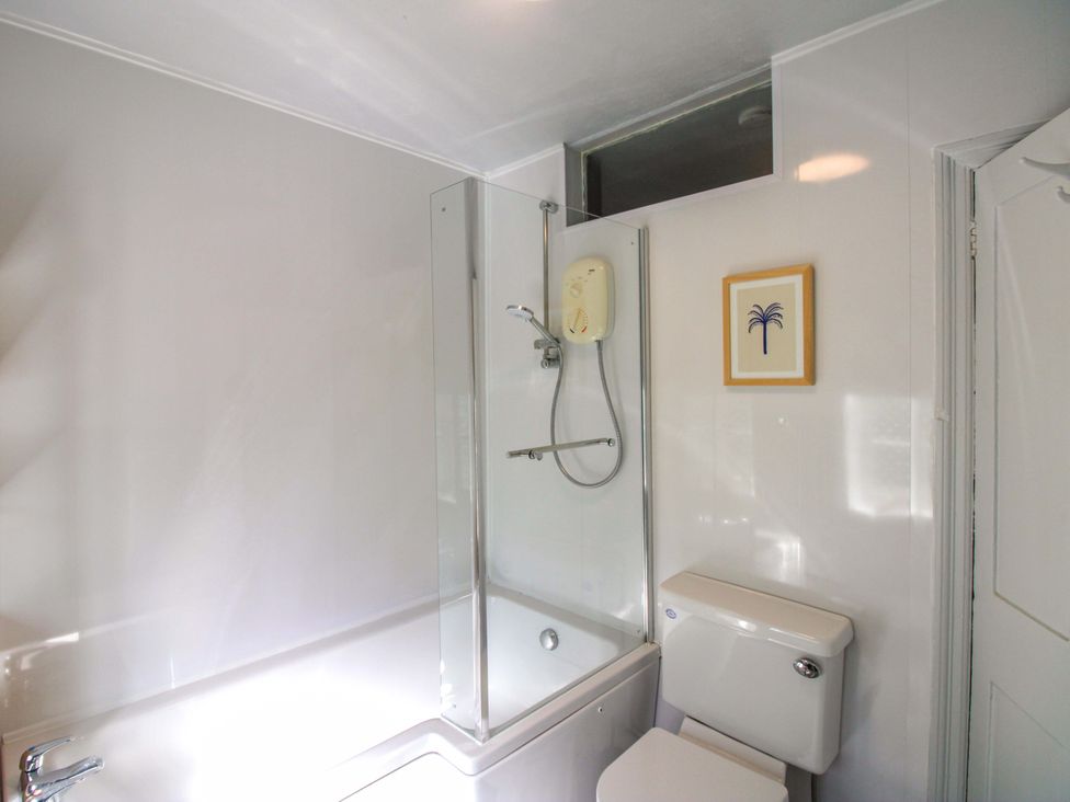 A bathroom with a bathtub and toilet at Rockside in Salcombe