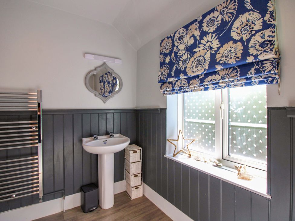 A bathroom with a wash basin and mirror at Rockside in Salcombe