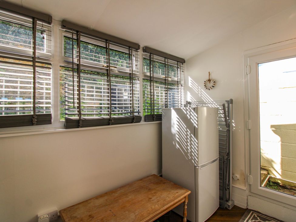 A kitchen with a refrigerator and table at Rockside in Salcombe