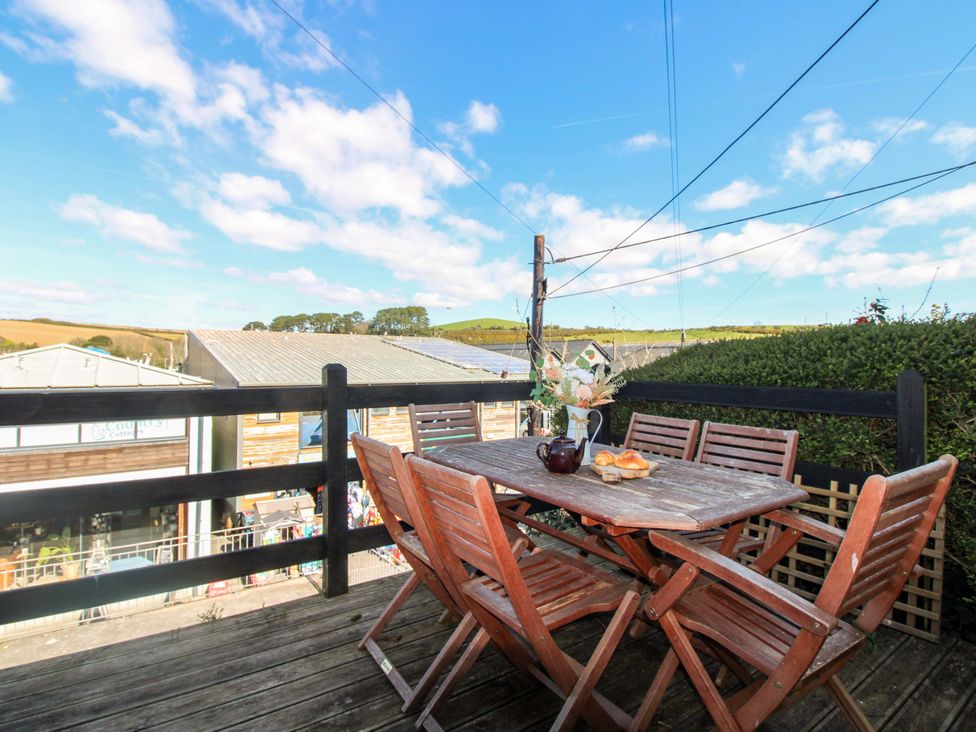 An outdoor seating area with a table and chairs at Rockside in Salcombe