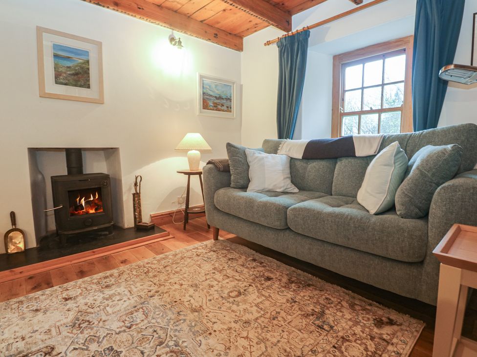 A living room with a sofa and fireplace at 1 Rowes Cottages Penzance