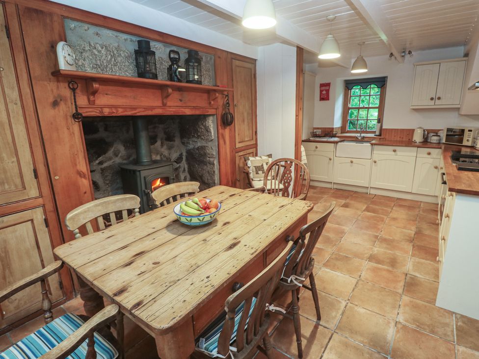 A kitchen with a wooden table and chairs at 1 Rowes Cottages in Penzance