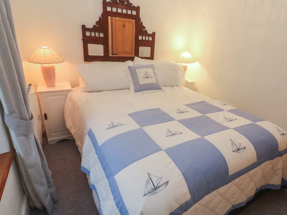 A bedroom with a bed and bedside tables at 1 Rowes Cottages in Penzance