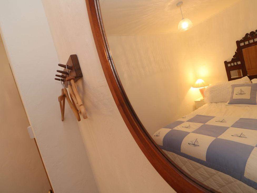 A bedroom with a bed and lamp at 1 Rowes Cottages in Penzance
