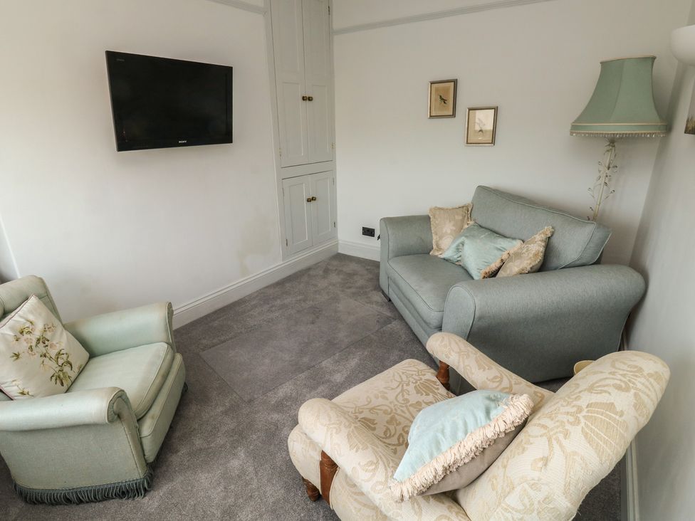 A living room with seating and a television at 13 School Road, Newton Abbot