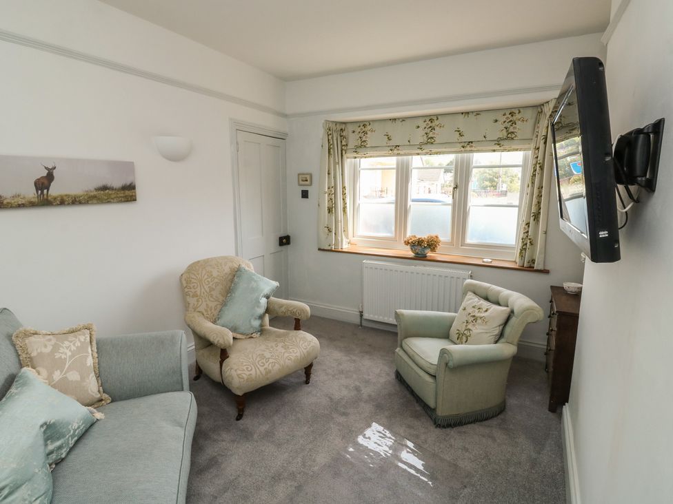 A living room with a sofa and armchair at 13 School Road in Newton Abbot