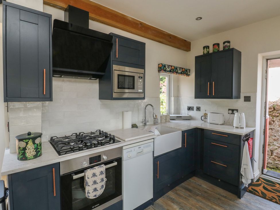 A kitchen with appliances and cabinets at 13 School Road in Newton Abbot