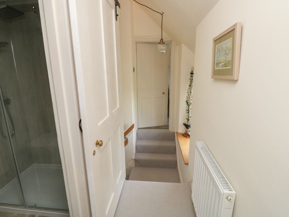 A hallway with stairs and a shower at 13 School Road in Newton Abbot