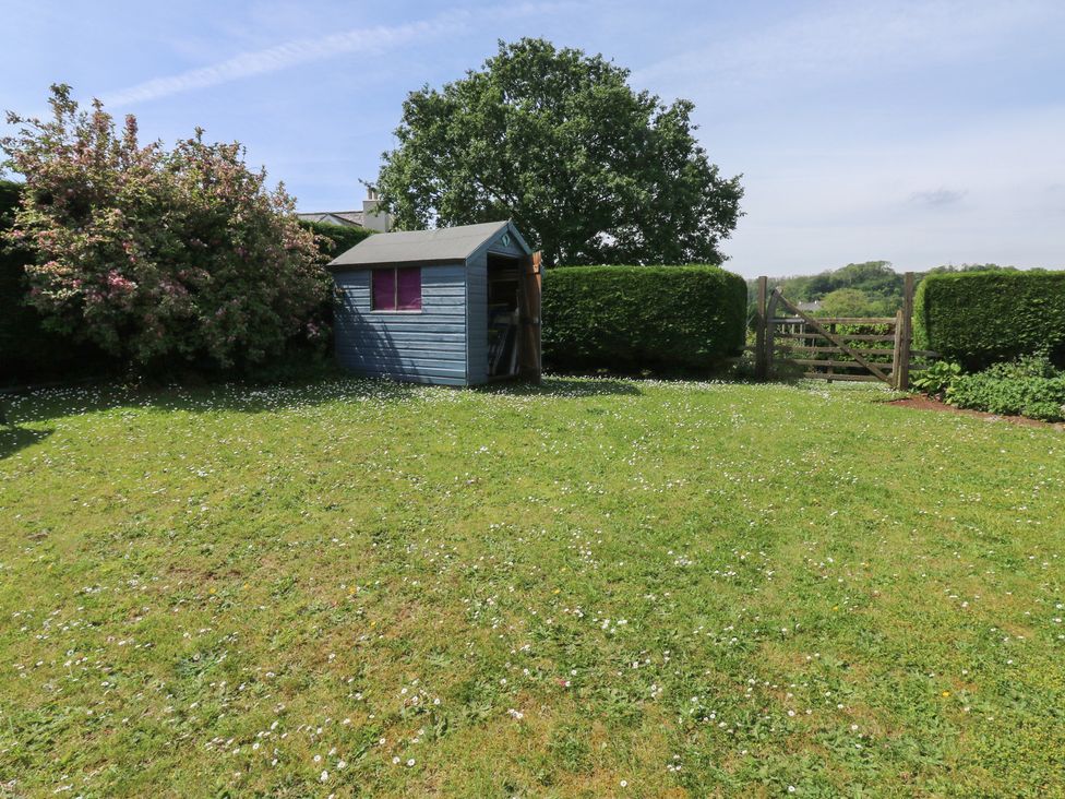 A garden with a shed and trees at 13 School Road in Newton Abbot