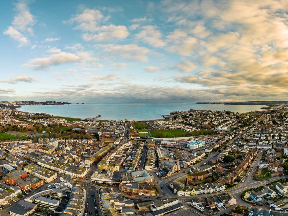 An aerial view of a coastal town with buildings and sea at 13 School Road, Kingskerswell