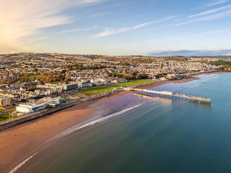 An aerial view of a beach with a pier and buildings at 13 School Road Kingskerswell