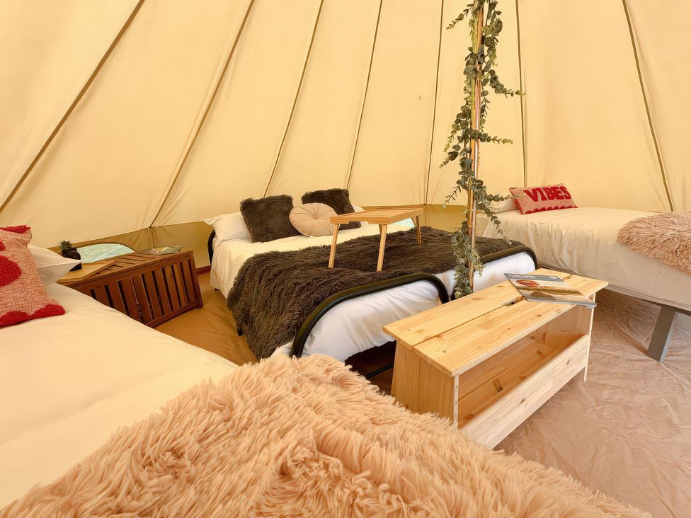 A bedroom with beds and a table at Bell Tent 