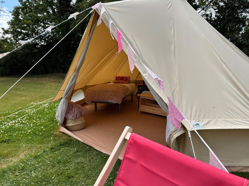A tent with a bed and a chair at Bell Tent in 