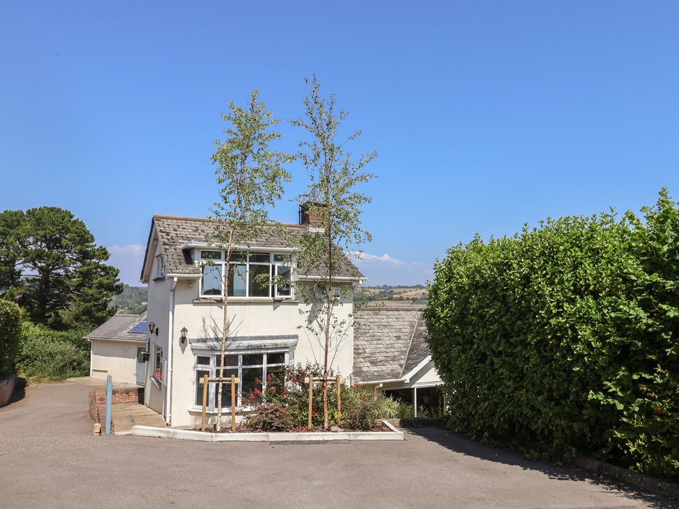 A house with trees and bushes in front at Hawksdown Lyme Regis