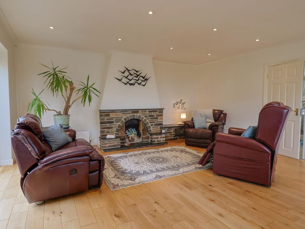 A living room with a fireplace and seating at Hawksdown in Lyme Regis